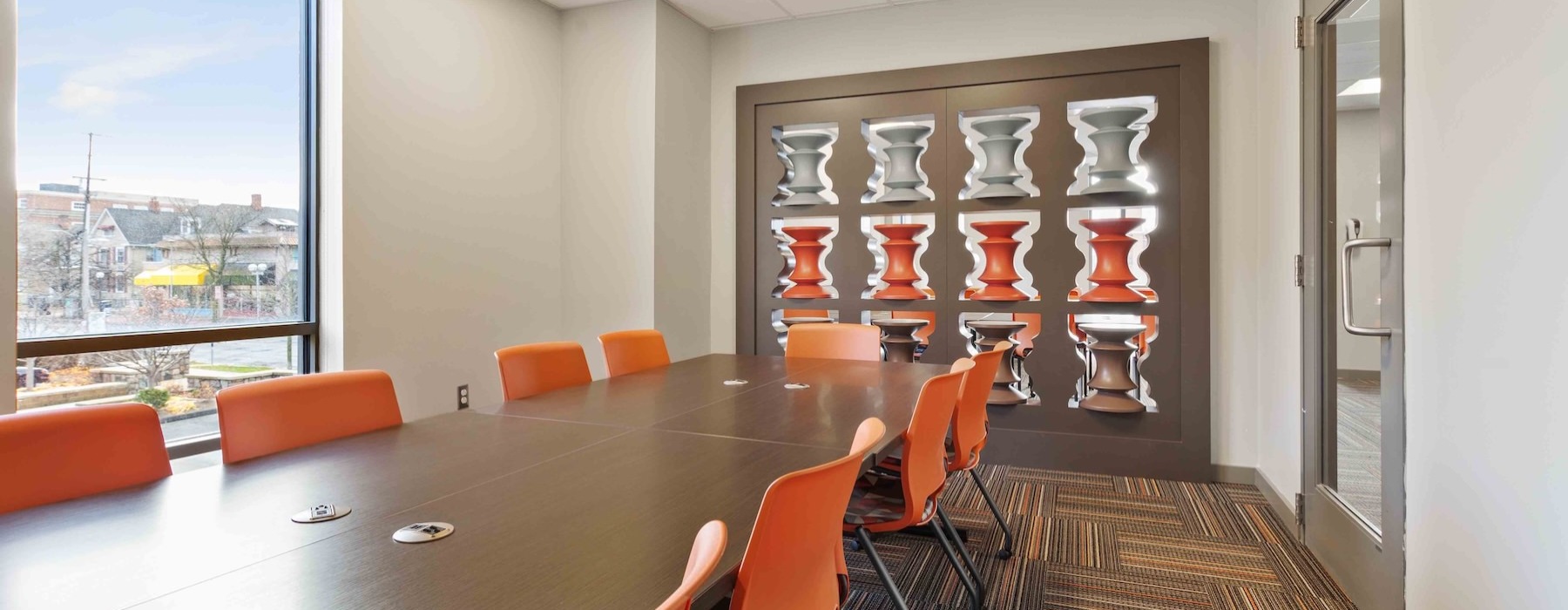 a conference room with a table and orange chairs